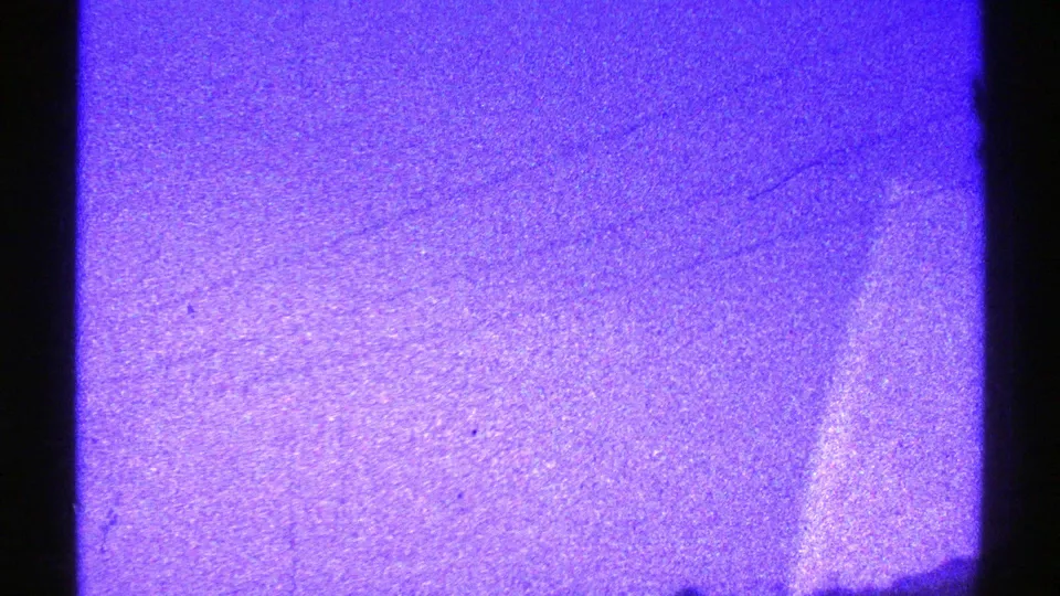 Final 1969 Nevada frame with blue-purple landscape, faint utility structure, and dark ground shape at the edge.