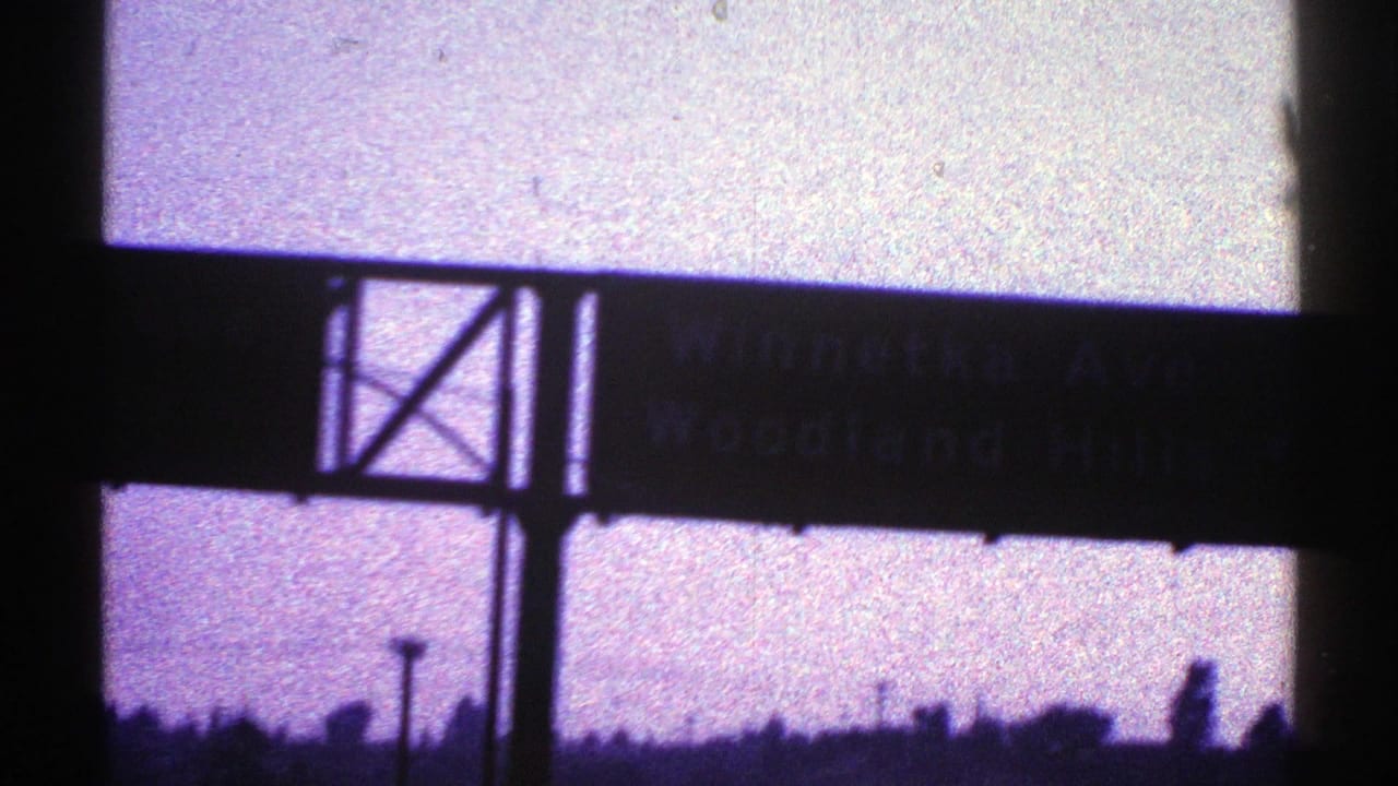 1969 Nevada highway frame showing an overhead sign that appears to include Winnemucca Avenue text, with silhouetted posts and skyline.