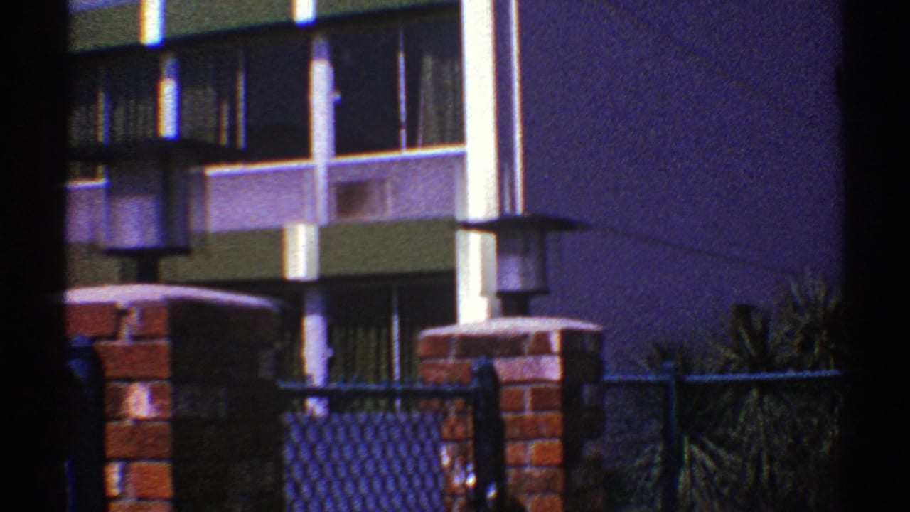 Closer view of windows, green facade band, brick pillar, and lamp post.