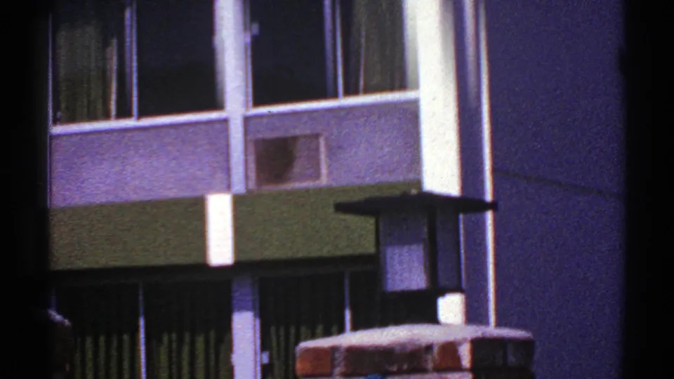 1969 Nevada 8mm view of the building's windows, green-and-white facade, dark entrance area, and foreground brickwork.