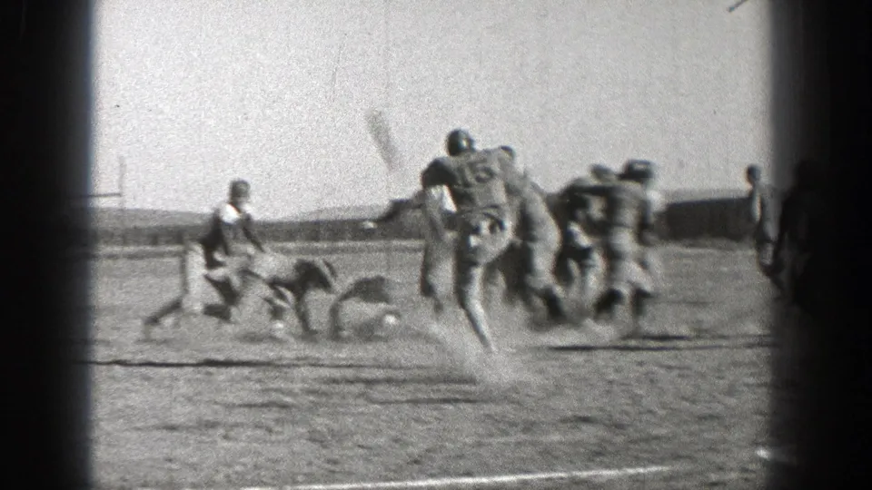 Washington 1938 football action with helmeted players moving across a grass field during a home-movie game sequence.