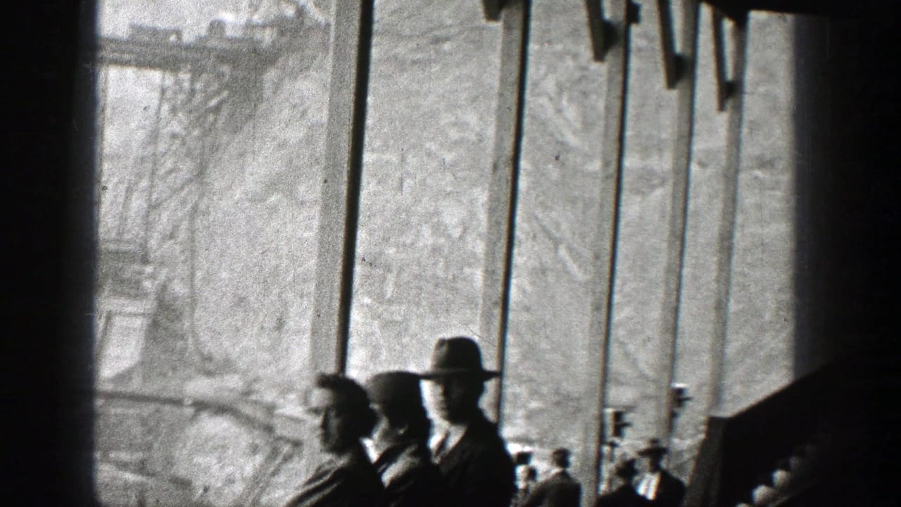 Onlookers stand near bridge railings while watching activity beyond the frame.