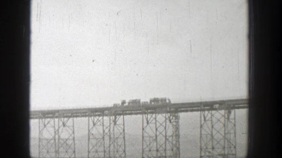 1938 Washington frame showing distant vehicles on a raised bridge, photographed with soft focus and visible film wear.