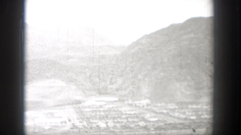 1938 Washington 8mm frame showing a bright, soft-focus valley or hillside view with water and possible buildings below.