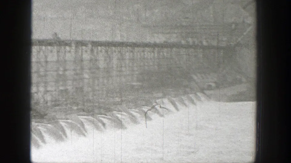 Soft 8mm frame showing dam or bridge construction framing over bright, fast-moving water in Washington.