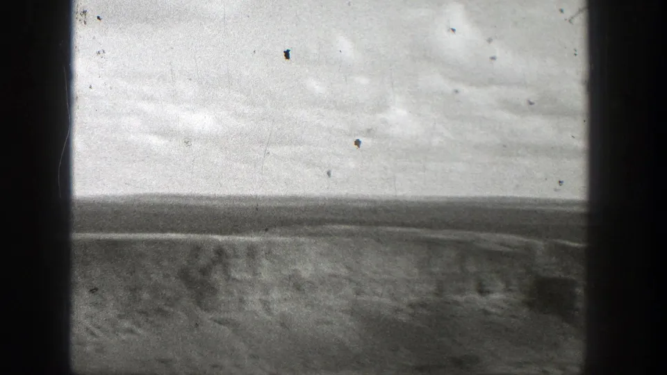 Washington 1938 8mm frame emphasizing open barren ground below the edge of an industrial structure.