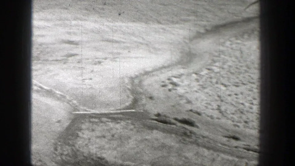 1938 Washington frame showing graded barren terrain below a distant steel industrial structure.