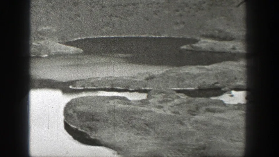1938 8mm view of rugged Washington terrain with reflective pools and heavy dark frame edges.