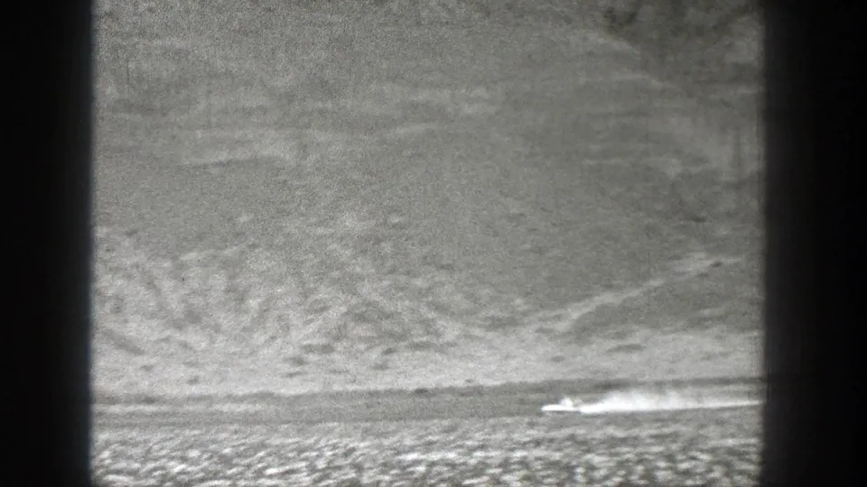 1938 Washington 8mm frame showing the small craft or aircraft farther along the open strip, with a widening smoke plume behind it.