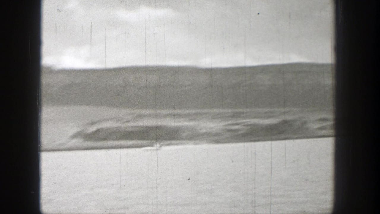 Open water and distant shoreline seen between dark vertical frame bars.