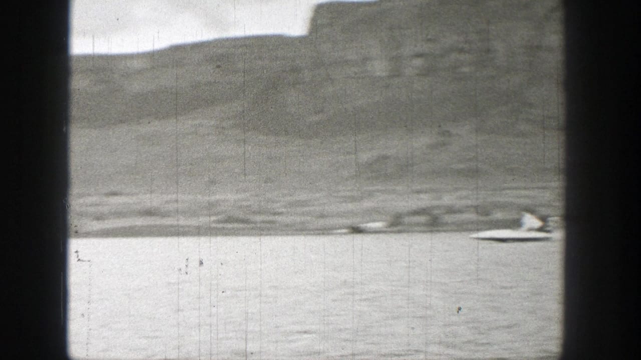 Lake shoreline and hills with a small boat near the right edge.
