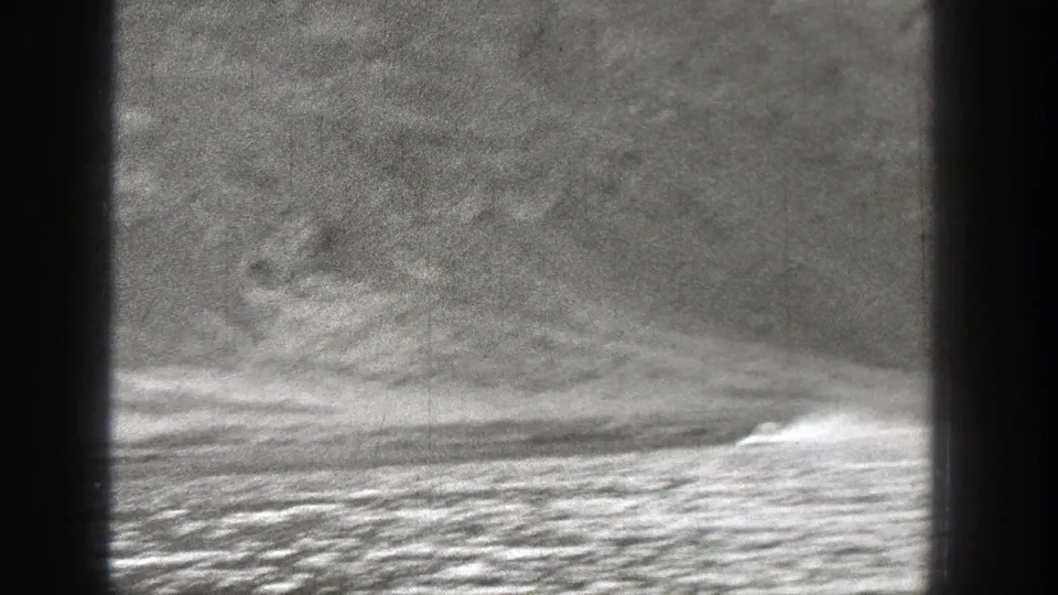 Small motorboat speeds across a Washington lake, leaving a white wake against a steep mountain background.