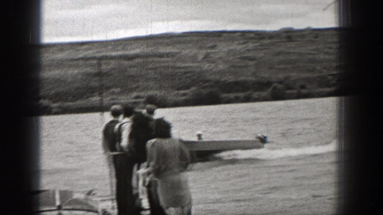 Washington shoreline spectators watch a small boat pass in this 1938 8mm home-movie frame.