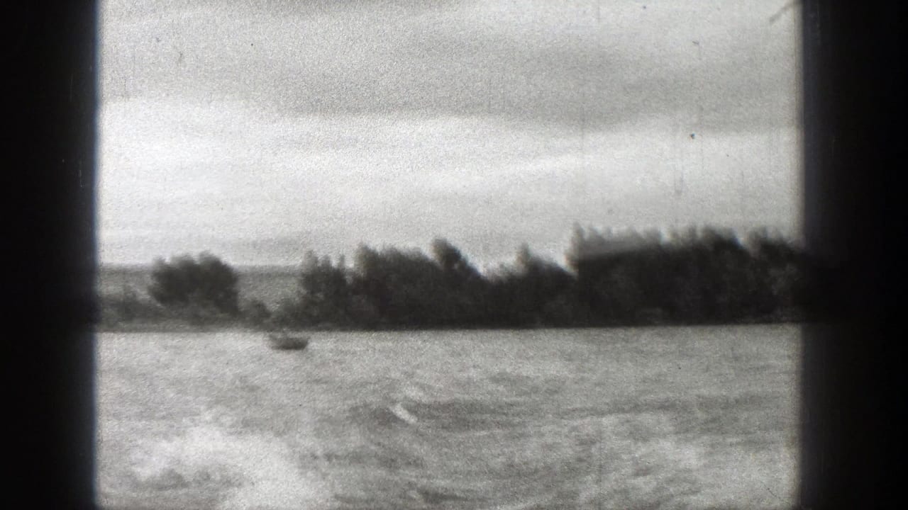 Small boat on choppy water beyond dark vertical framing bars.