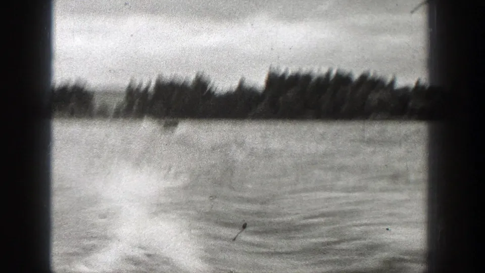 Black-and-white 8mm view of open water, wake patterns, and a wooded shore in Washington, 1938.