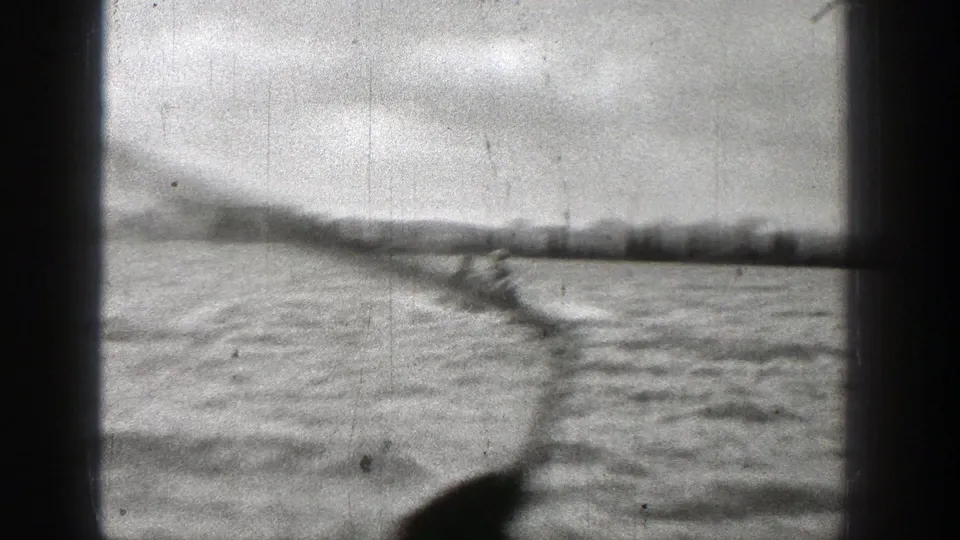 1938 Washington home-movie frame with the speedboat partly low in frame and a long wake trailing across the water.