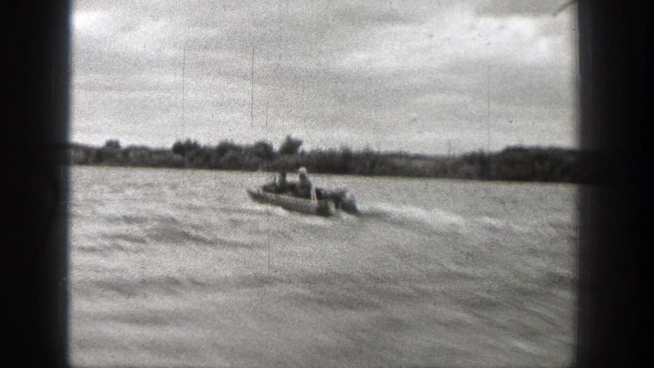Two riders in a small speedboat cross a Washington body of water in this 1938 black-and-white 8mm home-movie frame.