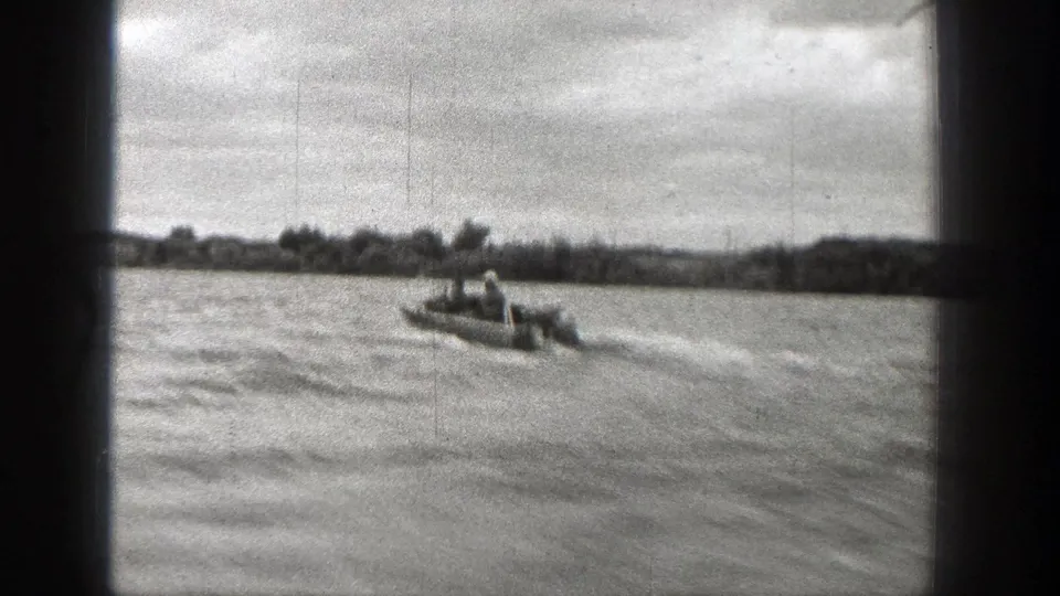 Two riders in a small speedboat cross a Washington body of water in this 1938 black-and-white 8mm home-movie frame.