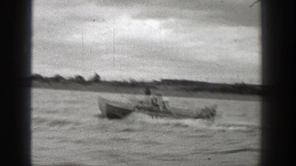 A closer 1938 Washington frame shows the small boat passing with people seated inside and a blurred riverside landscape behind.