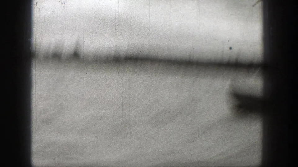 Soft, partially obscured river frame from the 1938 Washington clip, with distant shoreline and a boat edge entering at right.