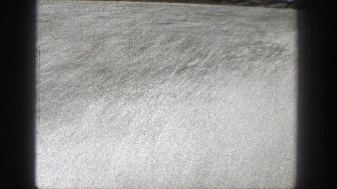 Bright rippled water with dark frame edges and visible film texture.