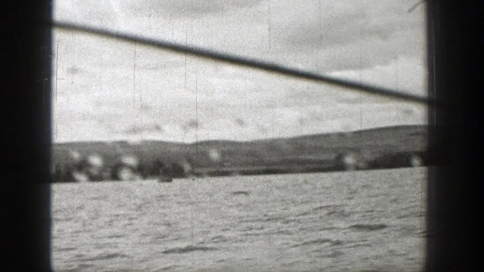 Black-and-white vessel view of rippled water, low shoreline, cloudy sky, and diagonal framing in Washington, 1938.