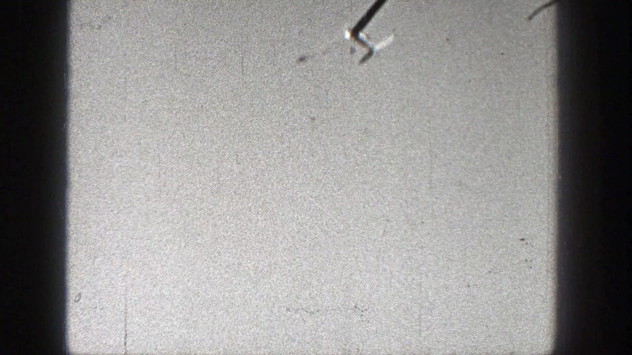 Mostly pale sky with dark vertical frame edges and faint film marks.