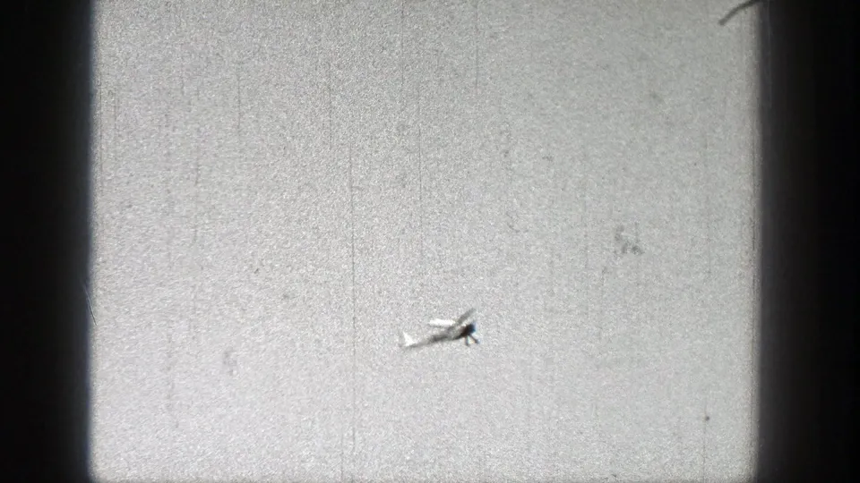 The model aircraft is seen at a distance against bright sky, consistent with the supplied 1938 Washington 8mm home-movie context.