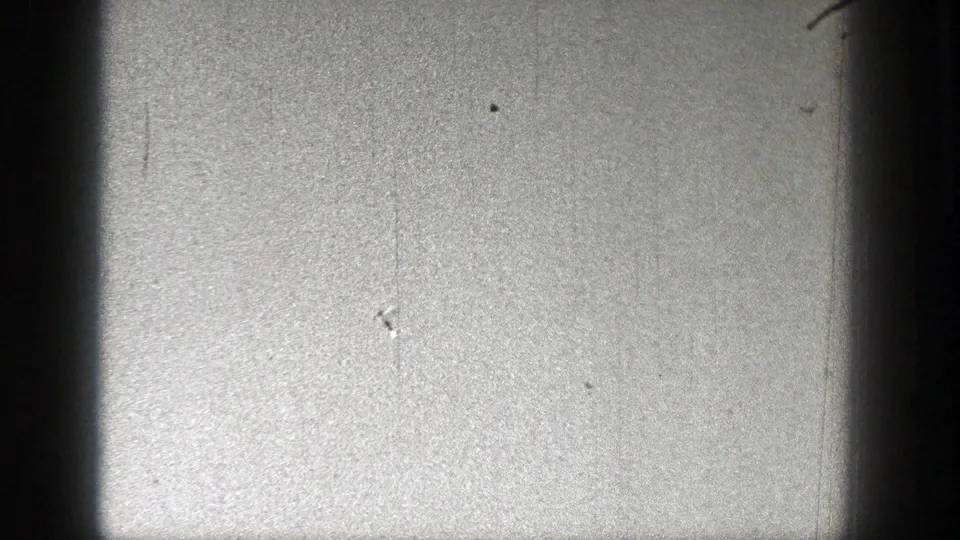 A distant airplane silhouette appears lower in the frame against an open sky in archival 8mm footage from the 1938 Washington clip.