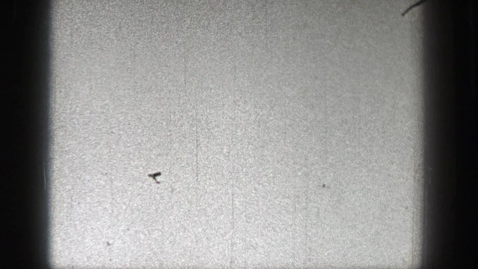 Near the end of the clip, the aircraft is a tiny dark mark against pale sky with pronounced grain and archival surface marks.