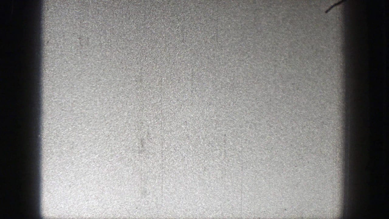 Washington 1938 home-movie frame showing a small plane against a bright sky, with dark vertical gate edges visible.