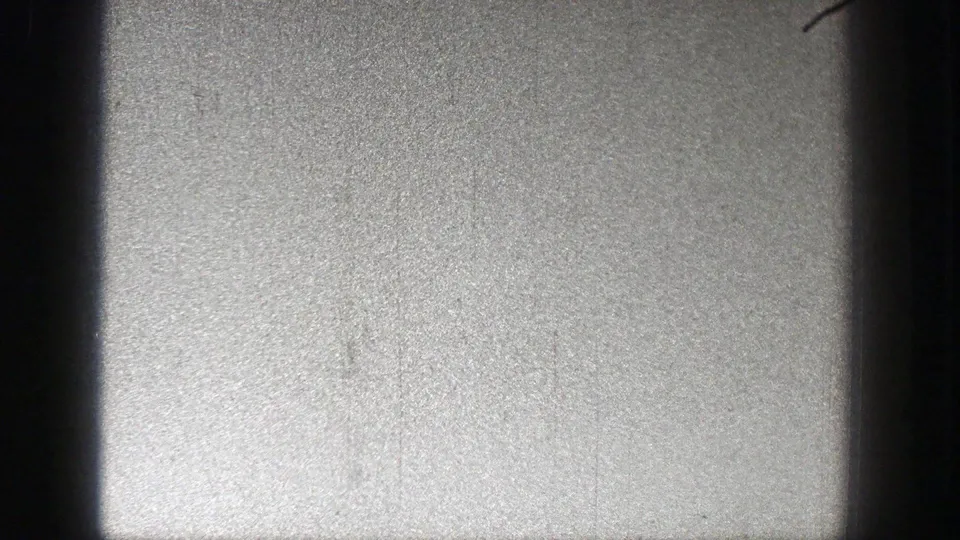 Washington 1938 home-movie frame showing a small plane against a bright sky, with dark vertical gate edges visible.