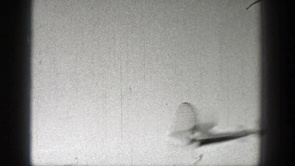 A small aircraft passes near the right side of the 1938 Washington frame, softened by motion blur and film grain.