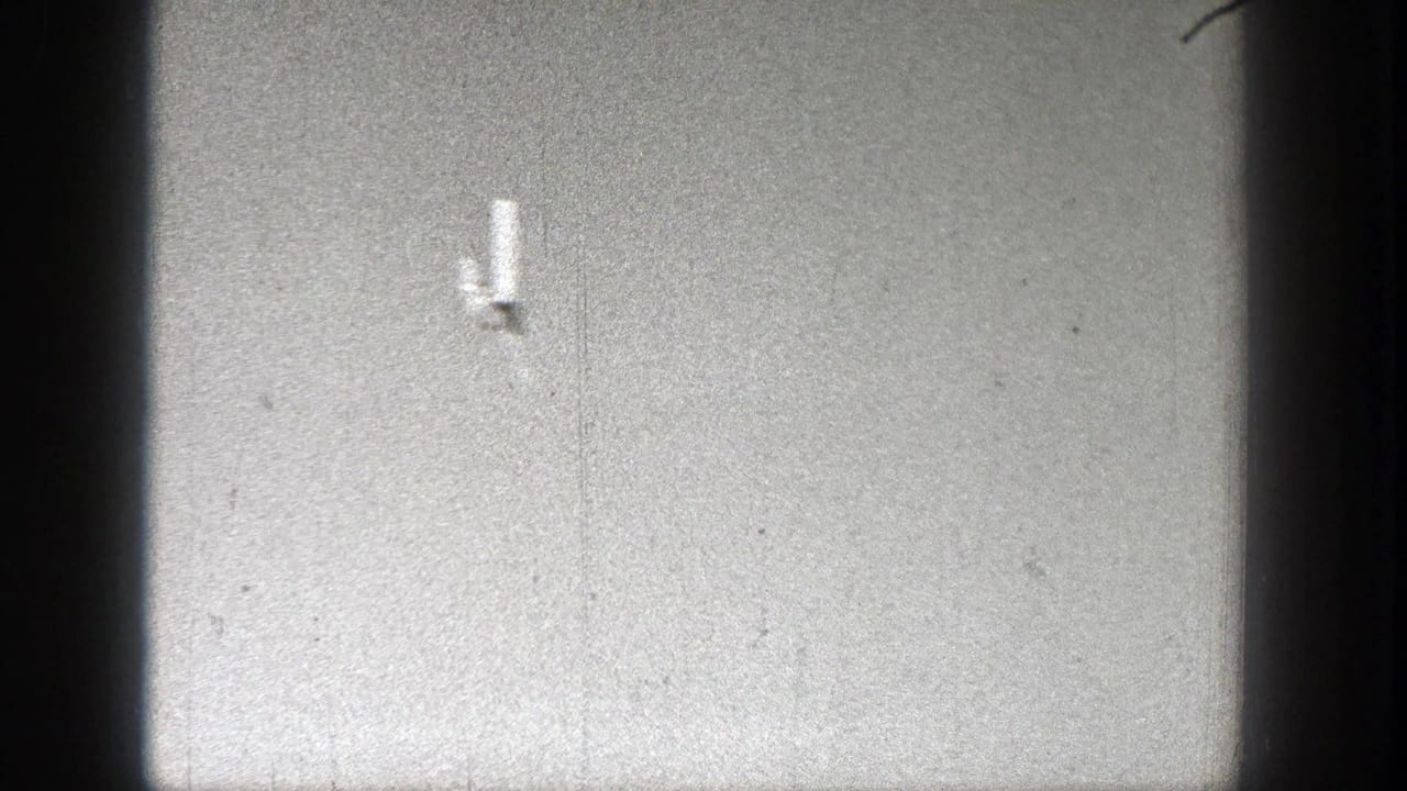 A small aircraft crosses the sky in metadata-supported 1938 Washington home-movie footage, framed by dark 8mm film edges.