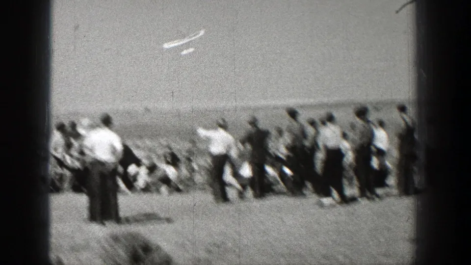 Spectators in an open Washington field watch a small aircraft overhead in grainy 1938 8mm home-movie footage.