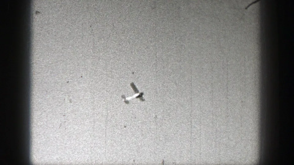 The aircraft is seen farther away against a grainy gray sky in the 1938 Washington home movie.