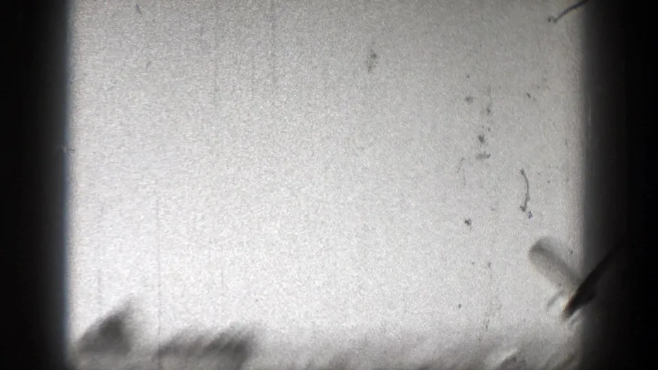 A blurred aircraft-like form appears near the lower right edge of the 1938 Washington sky frame, with heavy grain and gate shadowing.