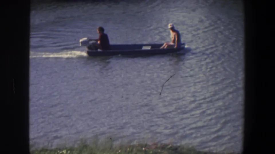 The small motorboat continues across calm water, with two riders visible and Saint Paul location supported by metadata.