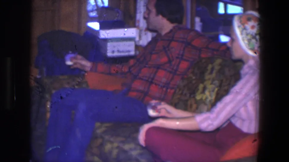 1971 Saint Paul living-room frame of the couple seated together, with the man holding a drink and the woman facing left in profile.
