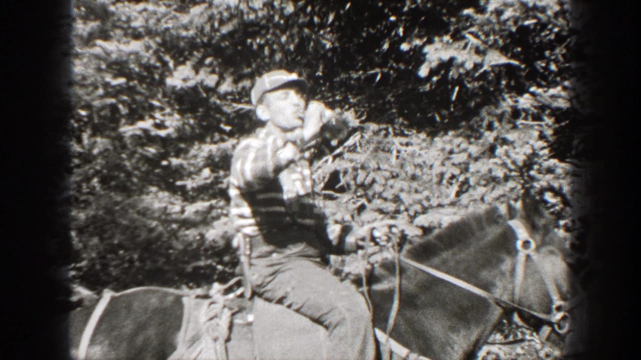 Adult man in a cap and striped shirt rides a saddled horse in a California pine forest, 1938 home-movie footage.