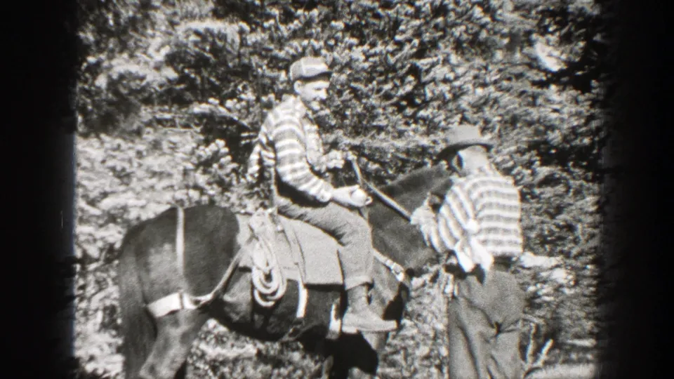 A rider on a saddled horse faces a standing man beside the horse in 1938 California home-movie footage.