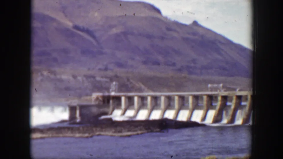 1938 California 8mm frame with the dam extending across the river and white water visible at the spillway.