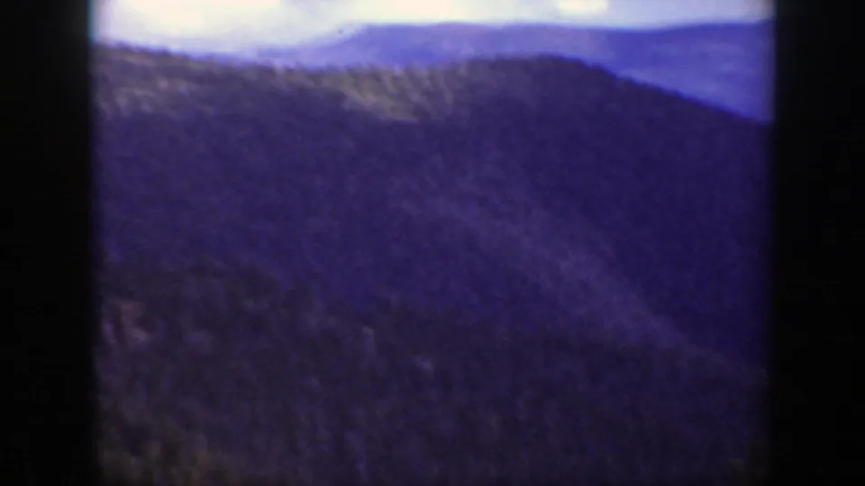Blue-toned 1938 California 8mm view of layered forested mountain ridges in soft focus.