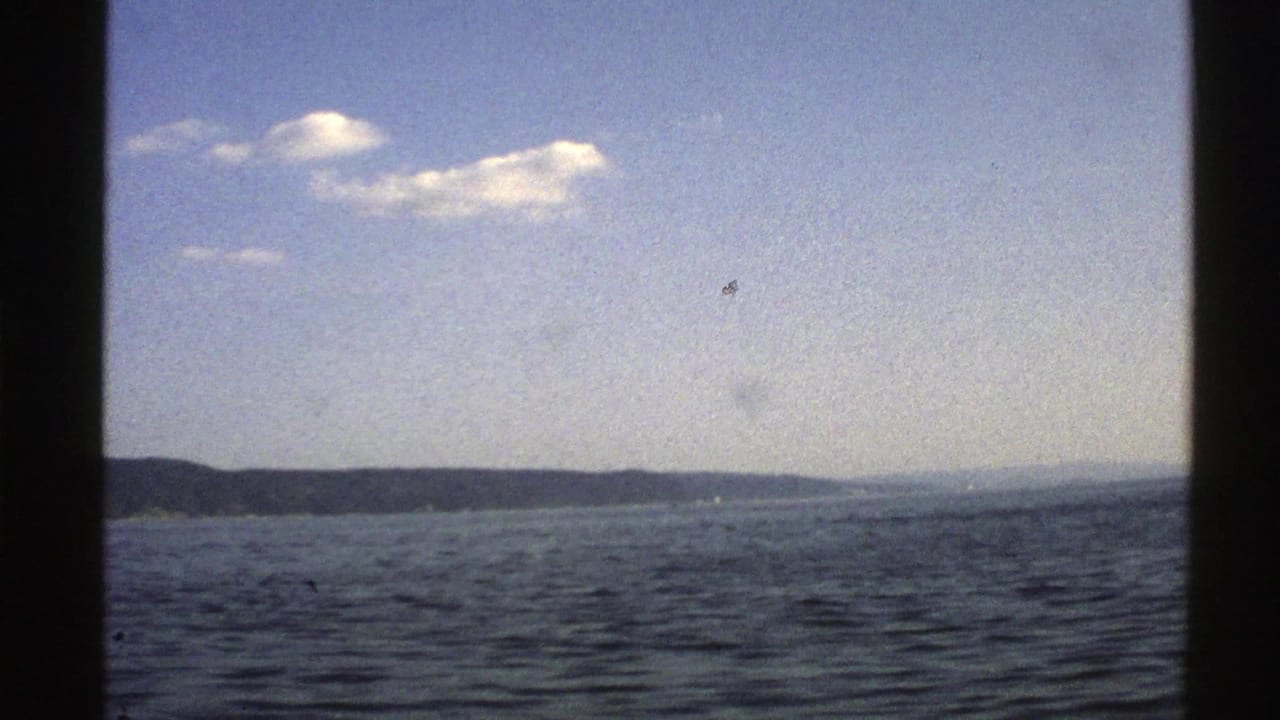 Distant landmass across the horizon with rippling water and clouds overhead.