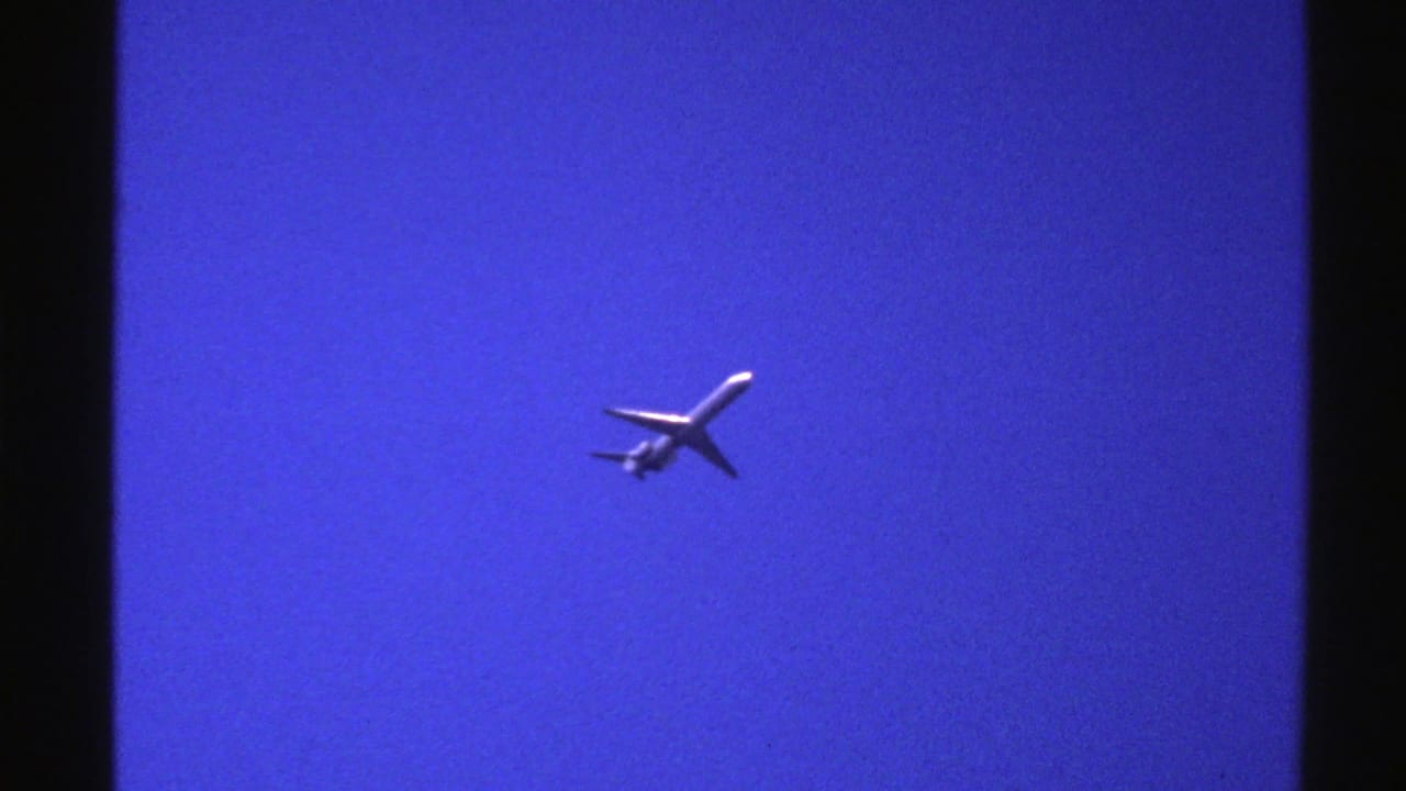 Passenger airplane seen from below against a deep blue sky.