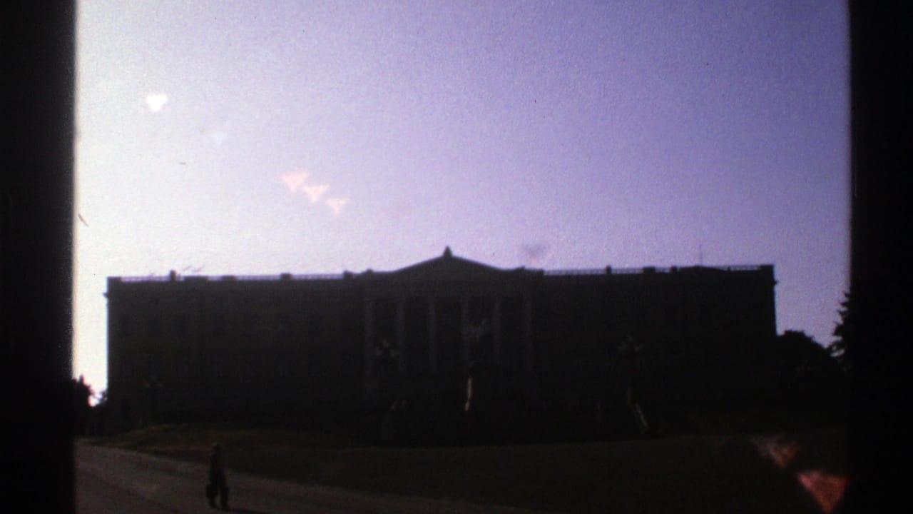 Silhouetted formal building with a lone figure walking in the foreground.