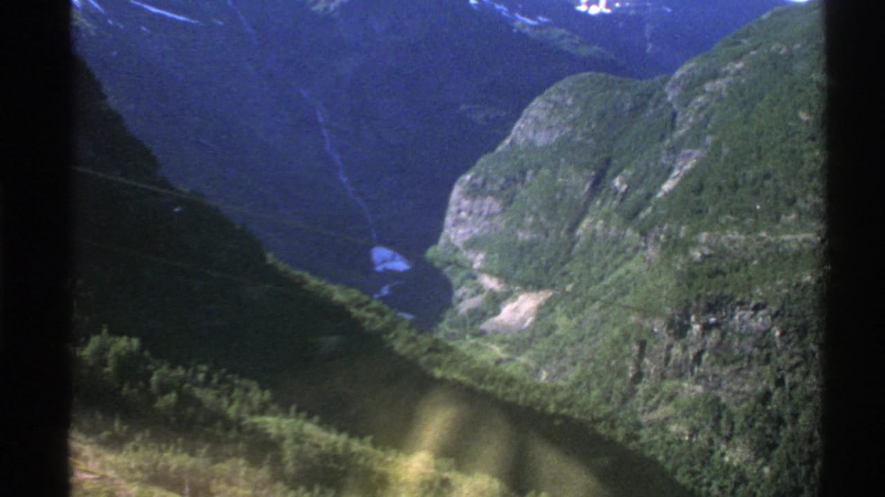Mountain valley seen through dark transportation window bars.
