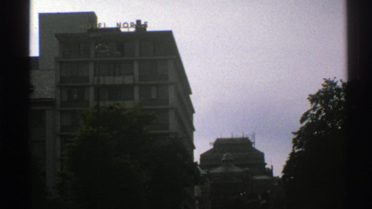 Hotel Norge building with trees in front and dark vertical framing at the sides.