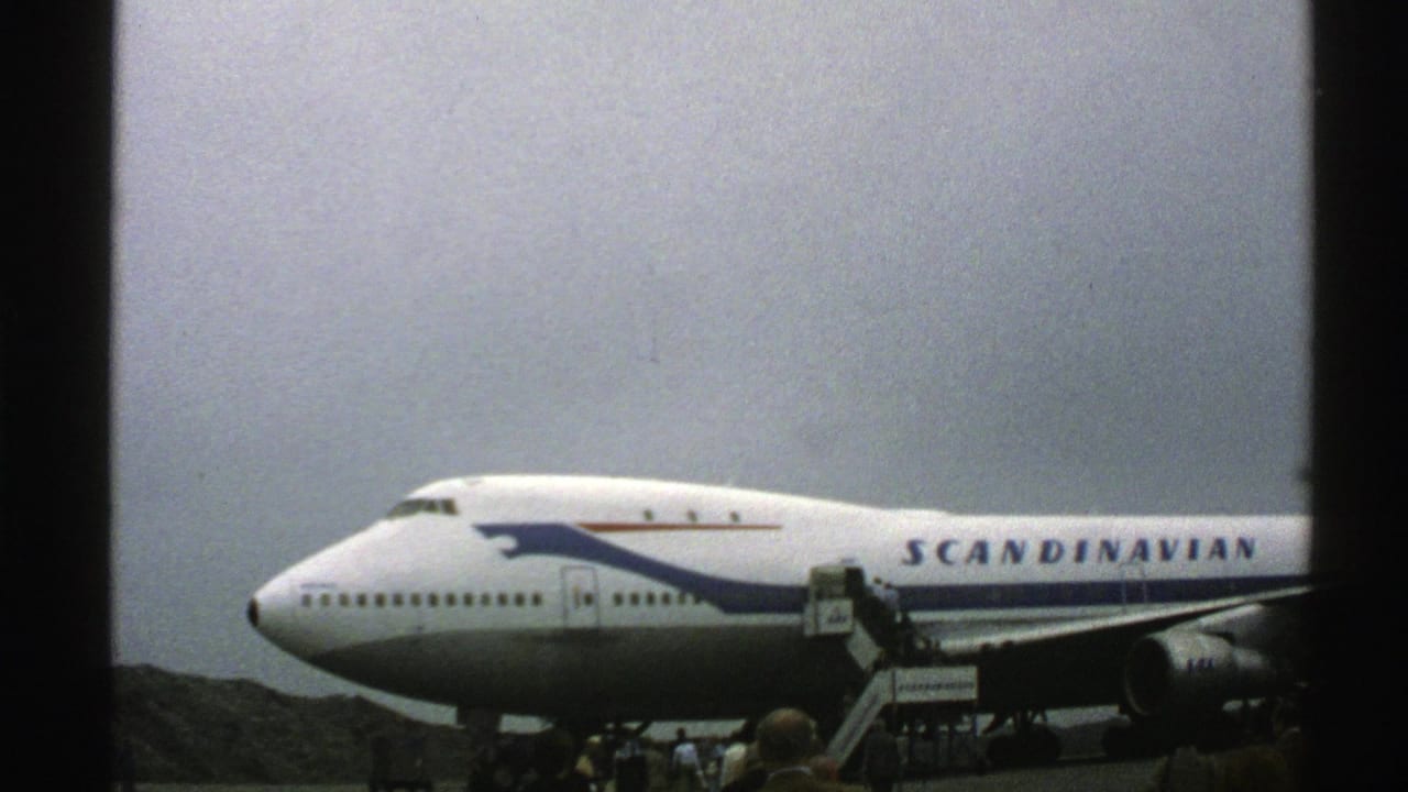 Side view of a Scandinavian Airlines 747 with boarding stairs at the door.