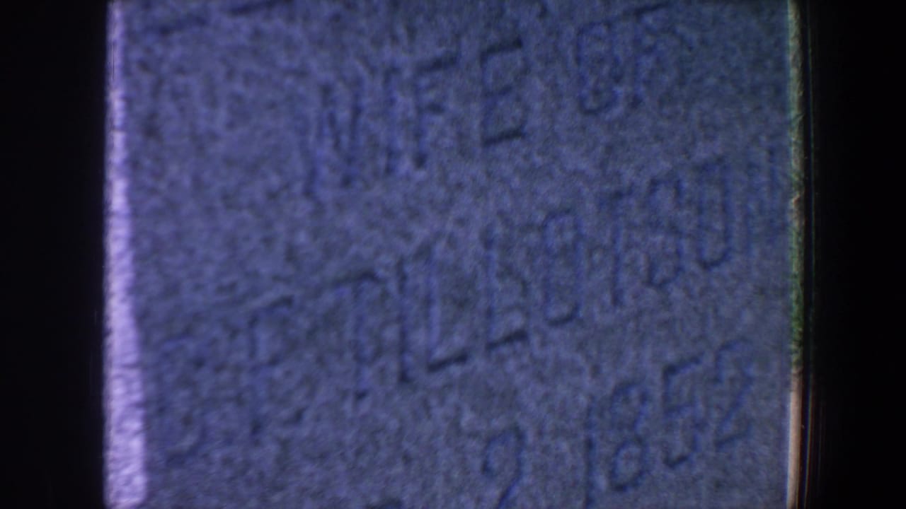 Close-up of gravestone lettering with parts of the name Elizabeth and date numerals visible.